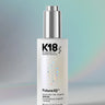 K18 hair serum dropper bottle on a gradient background